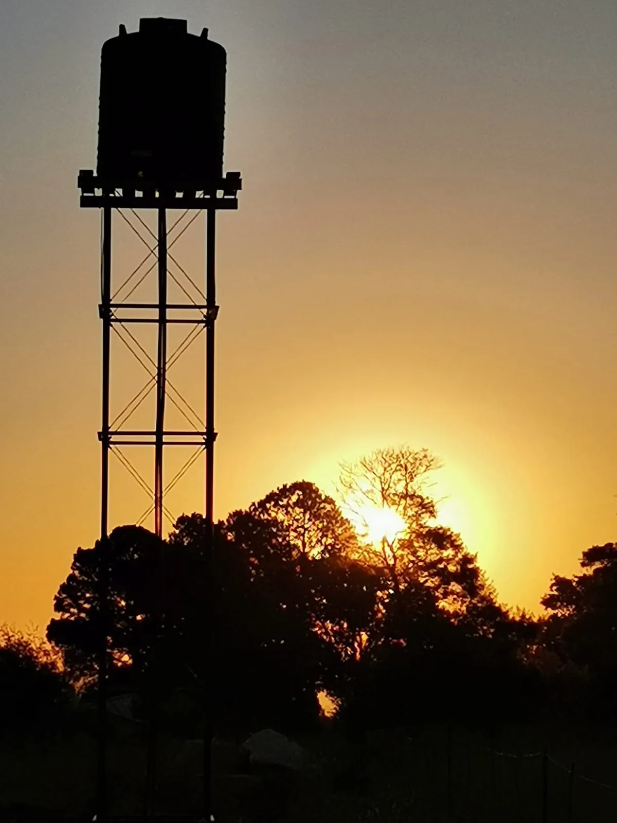 Water tank on a steel stand at sunset